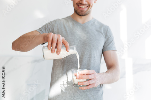 Fotografía Cropped photo of young handsome cheerful man drinking milk