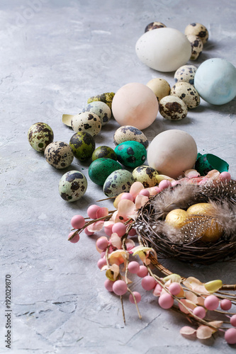 Easter decoration with colored quail and chicken eggs