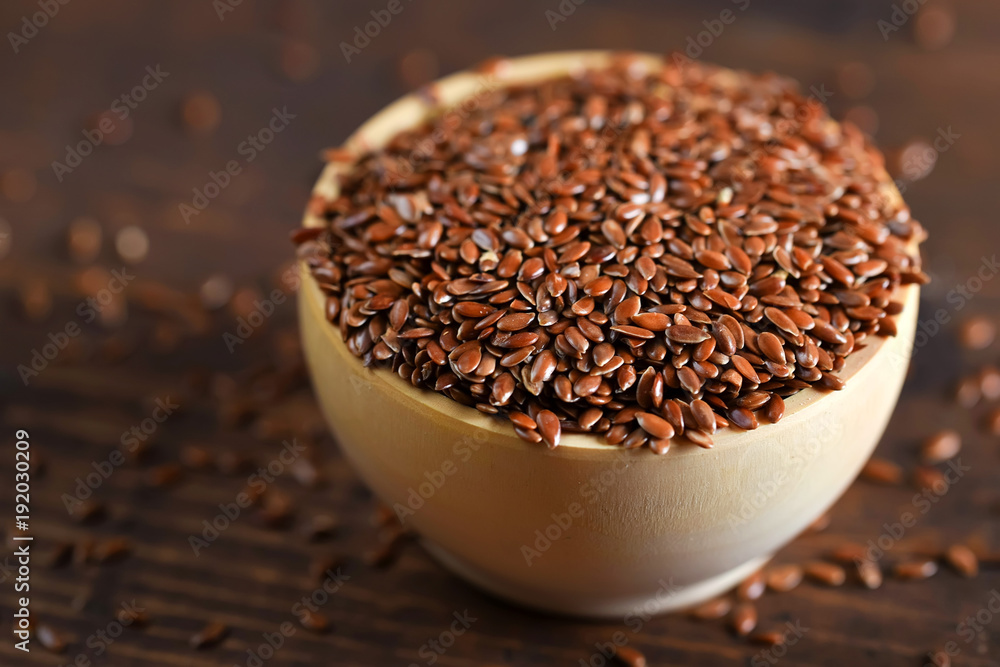 Close up linseed in wooden bowl on wooden table Close up linseed in wooden bowl on wooden table