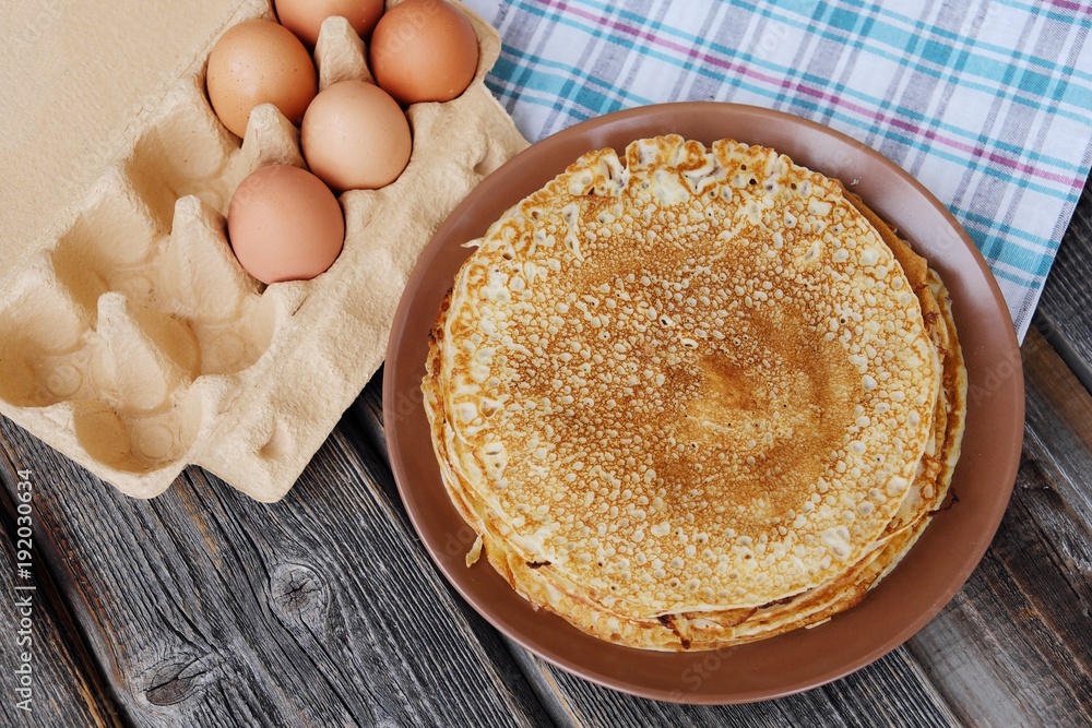 Fresh pancakes and eggs on a wooden table Fresh pancakes and eggs on a wooden table