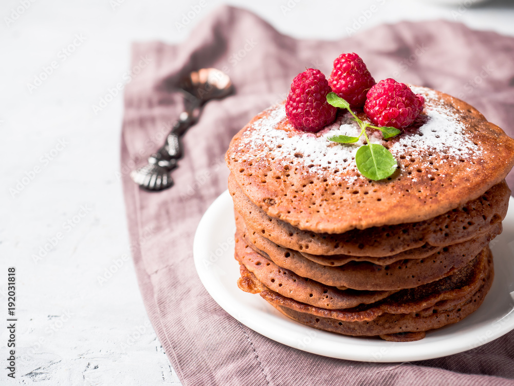 Chocolate pancakes with powdered sugar raspberry