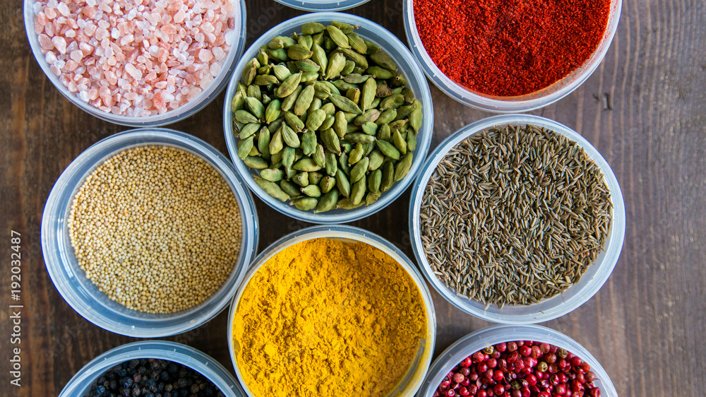 Various colorful spices in plastic containers