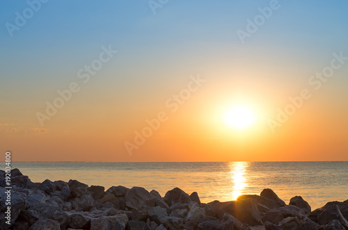 stony seashore against the backdrop of the sunrise
