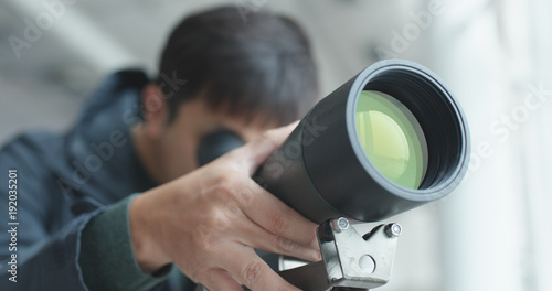 Fotografija Man looking through telescope to observe the bird habitat
