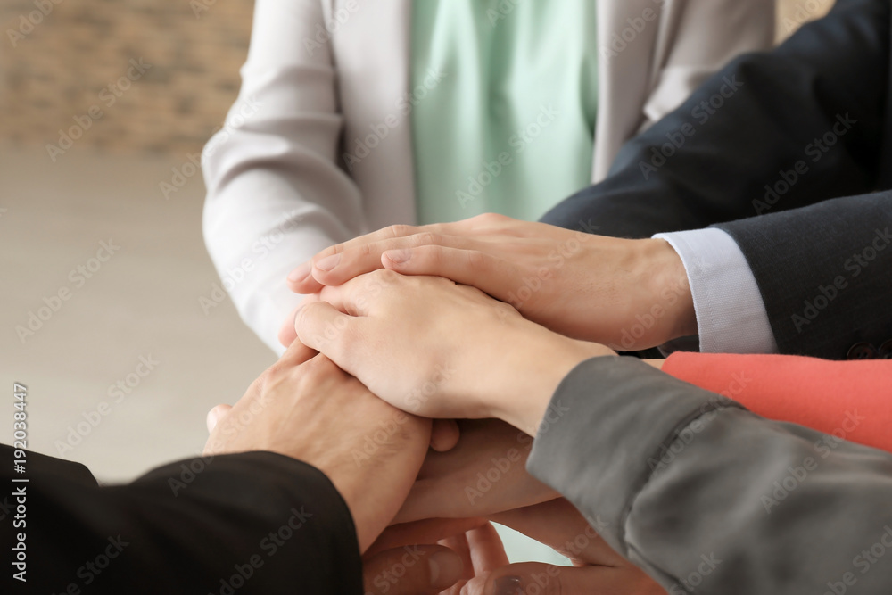 Group of people putting hands together as symbol of unity