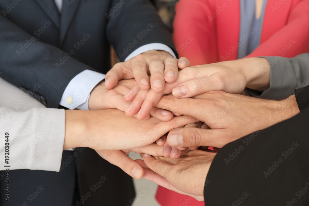 Group of people putting hands together as symbol of unity Group of people putting hands together as symbol of unity