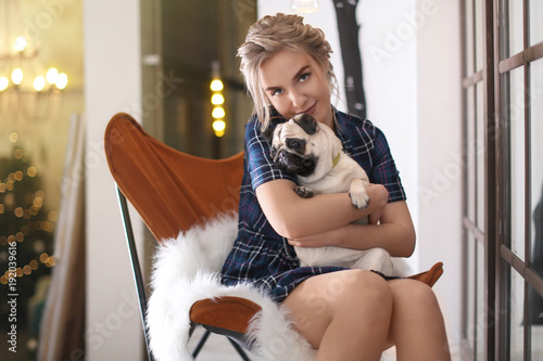 Young woman with cute pug d...