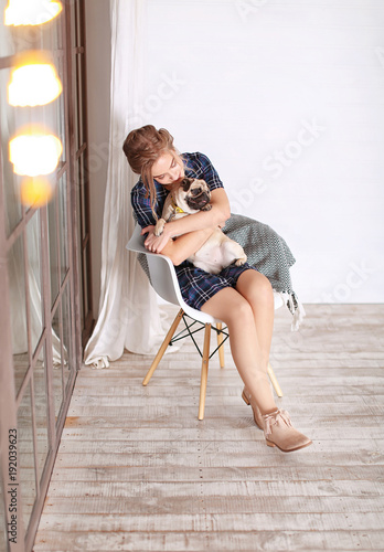 Young woman with cute pug d...