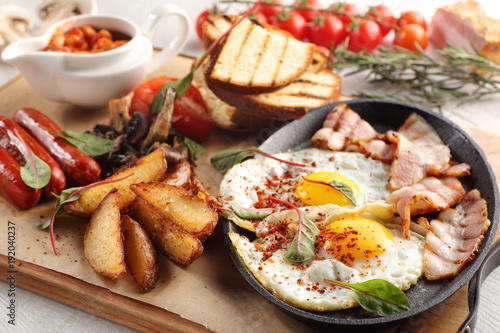 close up of rustic full english breakfast on a white wooden table