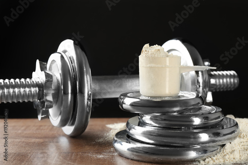Fotografie Measuring scoop with protein powder on  weight plates