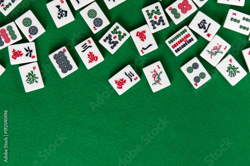 White-green tiles for mahjong on a brown wooden background. Blank space on the right