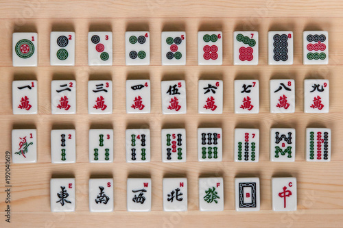 White-green tiles for mahjong on a brown wooden background.