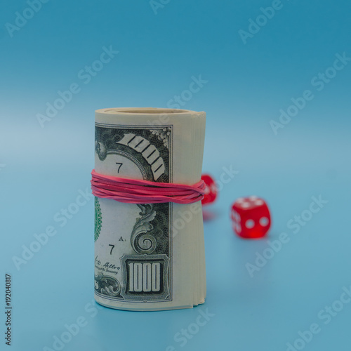 pack of dollars with dice on blue background