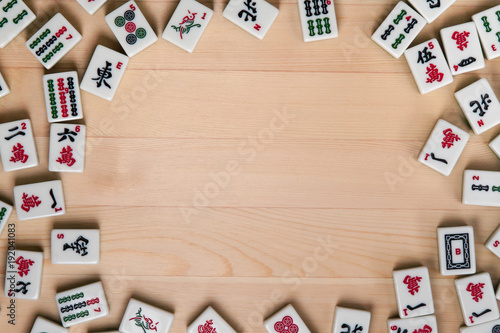 White-green tiles for mahjong on a background of light brown wood. Empty space in the center