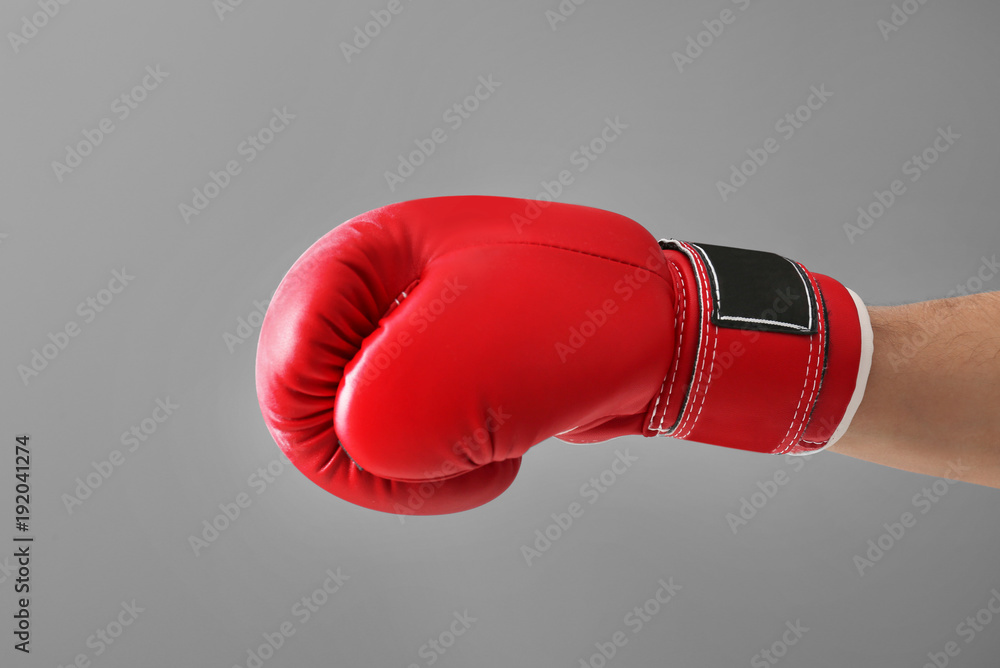 Man in boxing glove on gray background
