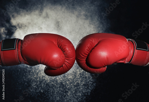 Men in boxing gloves on black background © Africa Studio