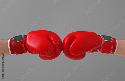 Men in boxing gloves on gray background © Africa Studio