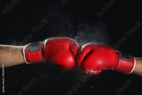 Men in boxing gloves on black background