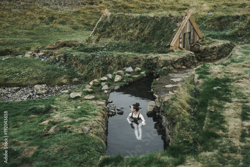 Caucasian woman swimming in pond near rural house photo