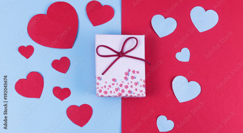 Gift or present box with red bow ribbon and glitter heart on rustic background for Valentines day.