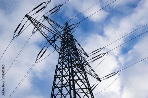 Power pole with a cloudy blue sky. Electricity power cabel tower.