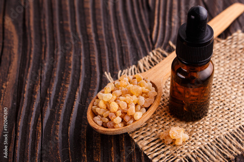 Fényképezés frankincense essential oil on a wooden background