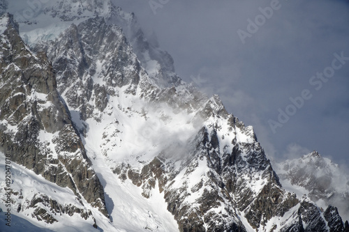 Granite mountains covered with snow and winter forest near Mont Blanc Alpes, Italy