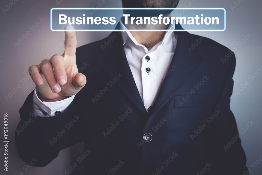 Man hand pressing on Business Transformation text on screen. Man hand pressing on Business Transformation text on screen.