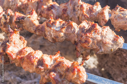 Mutton shish kebabs on skewers on the grill outdoors