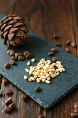 Clean pine nuts on black kitchen board.