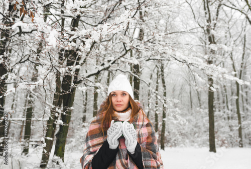 a girl in a plaid drinks tea in winter