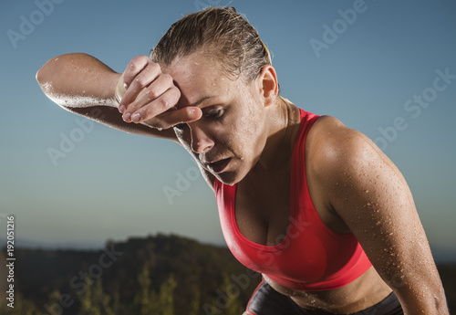 Close-up of woman wiping sweat from forehead photo