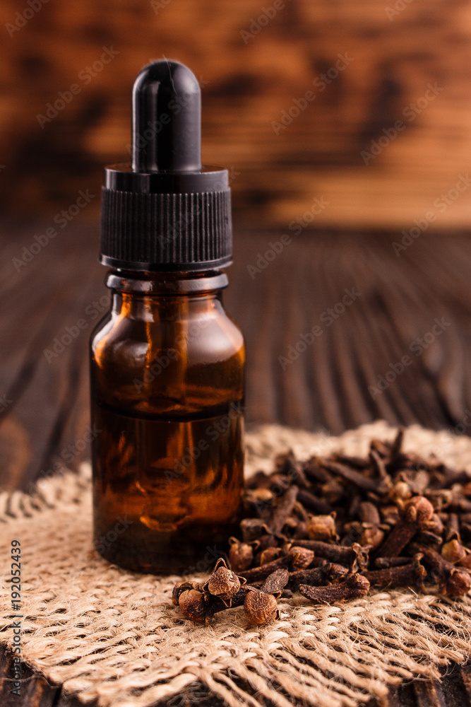 essential oil of cloves on a wooden rustic background essential oil of cloves on a wooden rustic background