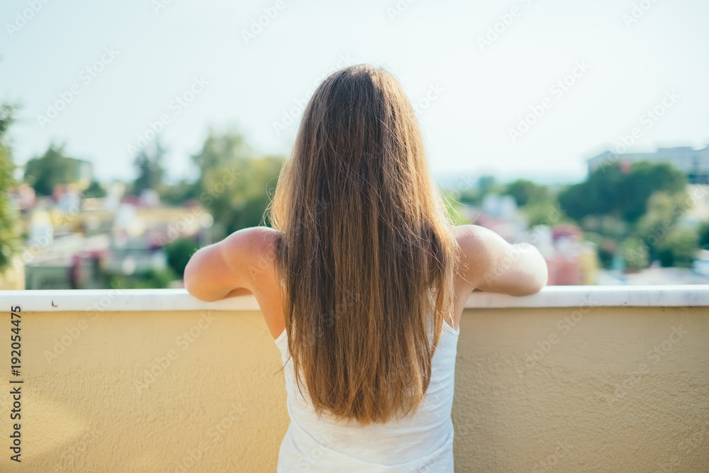 Summer portrait of young pretty woman with long hair standing backwards and  looking to the summer nature view. Girl enjoys nature paradise and fresh  air at wonderful summer vacation. Stock Photo |