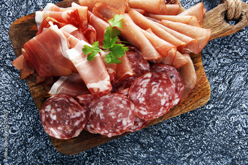 Food tray with delicious salami  pieces of sliced ham  . Meat platter with selection.