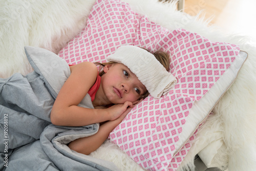 Young girl lying ill in bed at home. photo