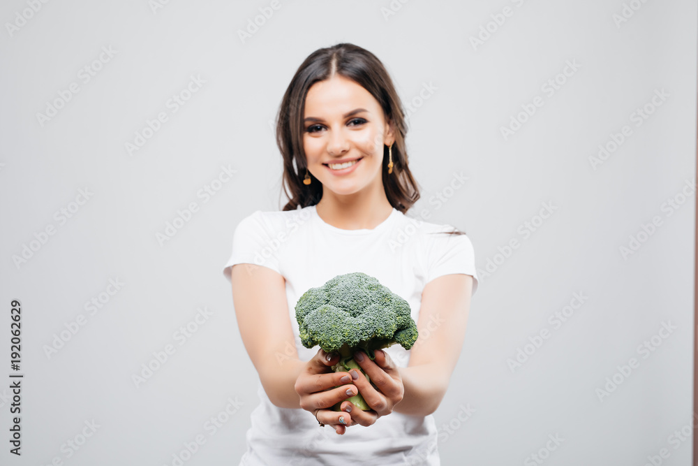 Portrait of a beautiful smiling woman with broccoli, isolated on white background Portrait of a beautiful smiling woman with broccoli, isolated on white background