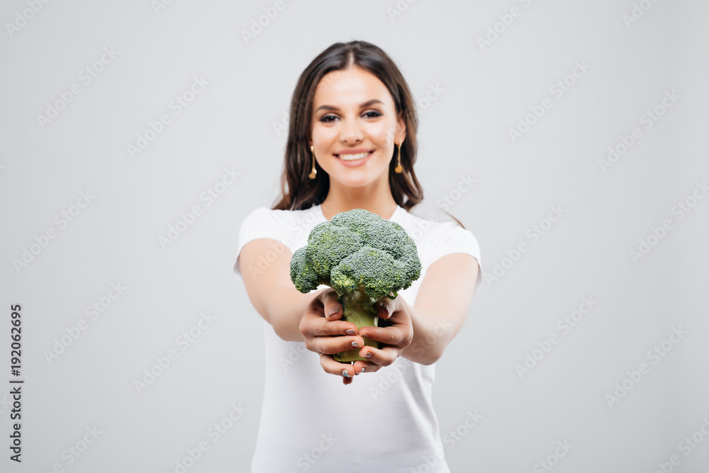 Portrait of a beautiful smiling woman with broccoli, isolated on white background Portrait of a beautiful smiling woman with broccoli, isolated on white background