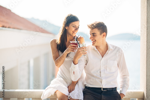 Loving couple spending vacation on tropical resort swimming pool.Newlyweds honeymoon on seaside.Couplr in true  love.Flirting and showing emotions.Affection.Celebrating anniversary.Making a toast