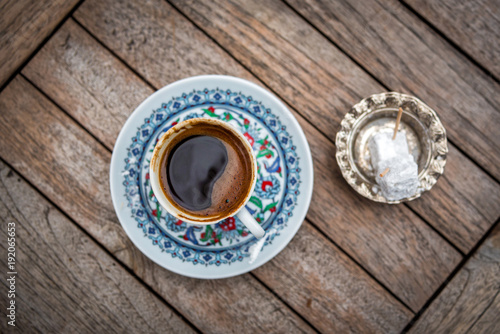 Turkish coffee in beautidful porcelain cup and lokum on a wooden table