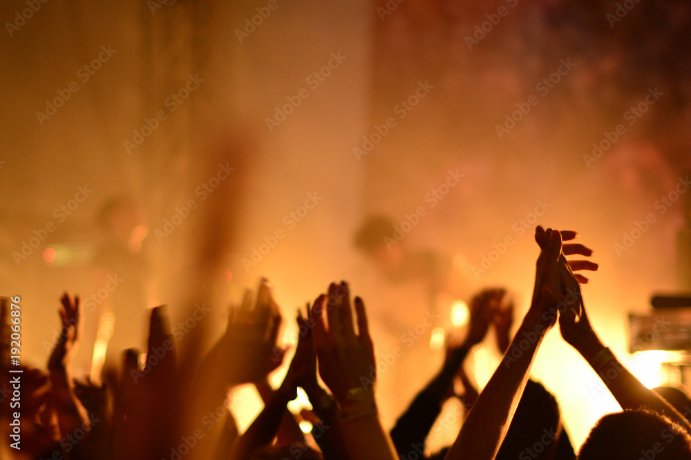 Silhouettes of concert crowd in front of bright stage lights Silhouettes of concert crowd in front of bright stage lights