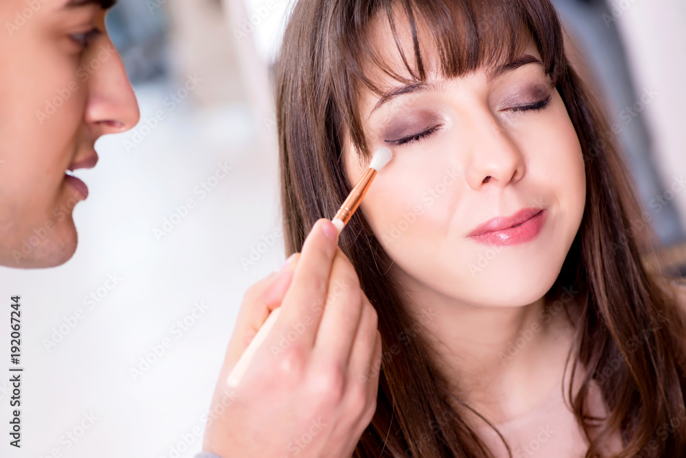 Man doing make-up for cute woman in beauty salon Man doing make-up for cute woman in beauty salon