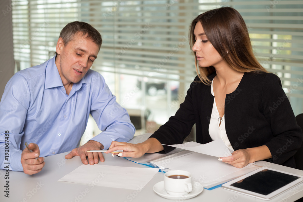 Fototapeta premium man and woman working in bright office classic suits and talk, solve the issues of the company