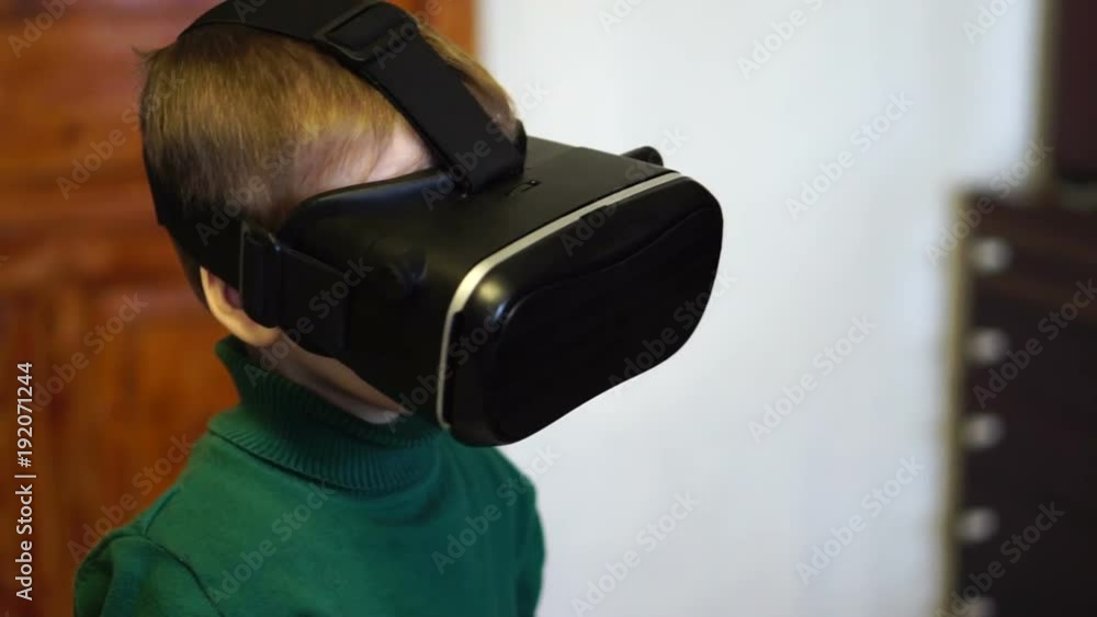 little boy uses virtual reality glasses. Slow motion. close-up little boy uses virtual reality glasses. Slow motion. close-up