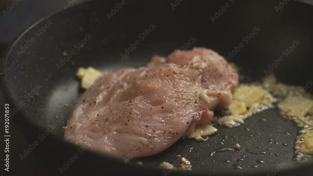 Man puts a chicken breast on a hot frying pan видео Man puts a chicken breast on a hot frying pan видео