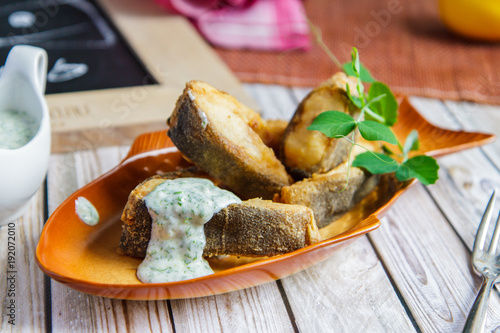 Fried tench with sauce on a beautiful ceramic plate