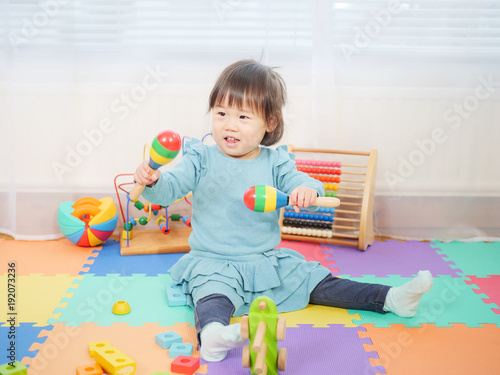 baby girl play maracas at home