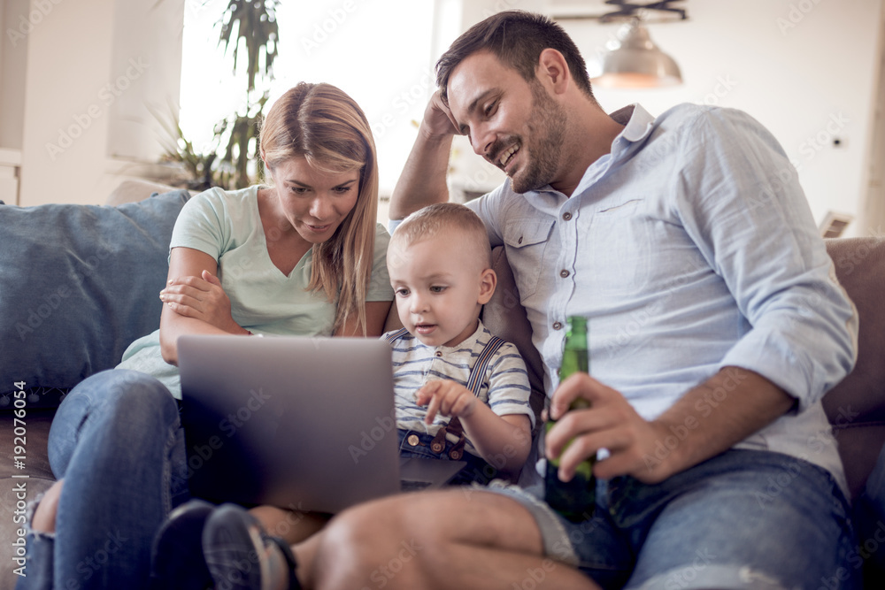 Happy caucasian family with laptop on sofa. Happy caucasian family with laptop on sofa.