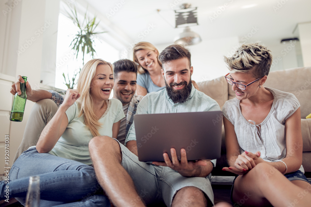Smiling friends looking at laptop Smiling friends looking at laptop