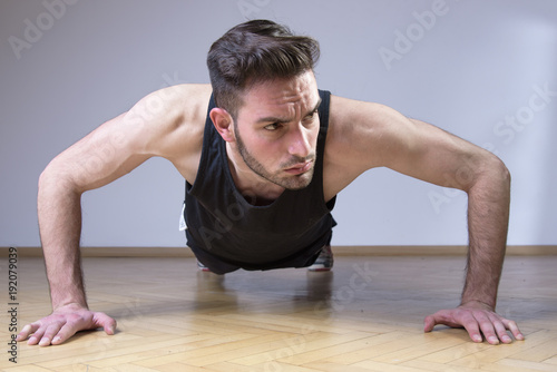 Young handsome athlete man doing push up exercises